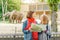 girls friends students watching at elephant family feeding in the zoo while navigating by map