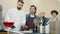 Girls and guys learning cooking watching chef preparing dish in modern kitchen