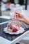 Girls hand holding a spoon with fruit vanilla cake