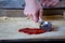 Girls hand  spreading sauce on pizza dough