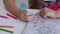 Girls hands draw with crayons in antistress coloring