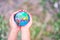 The girls\' hands gently held the globe gently. The background is a blurry green lawn.