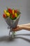 Girls hands hold Still life Bouquet of red and yellow unblown tulips, selective focus