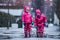 Girls are having fun in water on street in cold autumn day, girls splashing water in rain, cheerful girls enjoying cold weather