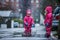 Girls are having fun in water on street in cold autumn day, girls splashing water in rain, cheerful girls enjoying cold weather