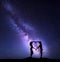 Girls holding hands in heart shape. Landscape with Milky Way