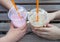 Girls holding plastic glasses of iced coffee and milkshake with straws in cafe on summer day