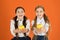 Girls kids school uniform orange background. Schoolgirls eat apples. School lunch. Vitamin nutrition during school day