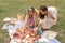 Girls laying out picnic food on a checkered picnic blanket