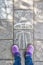 Girls` legs with a purple shoes on the pavement with chalk draw