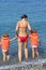 Girls in lifejackets with woman coming into sea