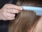 Girls making hair style, Brushing with blue comb light brown hair, Caucasian model