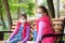 Girls in medical protective masks sit on a bench in the playground