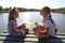 Girls are meditating on the pier at the lake