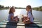 Girls are meditating on the pier at the lake