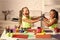 Girls painters painting with gouache paints on table