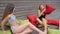 Girls played colored Pillows on background Wooden wall, Slender young women in bathing suits resting