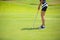 Girls are playing golf on a sunny day on the beautiful green golf course.