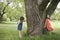 Girls Playing Hide And Seek By Tree