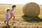 Girls playing with the round wheat dried bales
