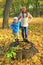 Girls posing standing on stump in autumn park. Happy childhood