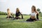 Girls practicing yoga on fitness mats on meadow