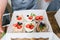 Girls prepare beautiful and tasty desserts on a wooden table and decorate with fruits