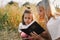 Girls reading holy bible in a wheat field. Study the holy bible together