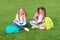Girls school pupils doing homework together on fresh air, summer vacation concept