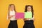 Girls school uniform hold poster. Visual communication concept. School friendship. School girls show poster