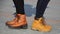 Girls in shoes, half-boots are standing on the sidewalk tiles in a Sunny evening