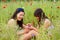 Girls sit together in poppy field