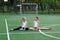 Girls sit on a twine on a sports field.