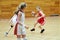 Girls in sport uniform playing basketball indoors