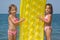 Girls standing on beach with inflatable mattress