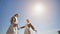 Girls students graduates holding hands on a sunny day.