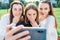 Girls teenage schoolgirls take pictures on phone, surprised, shocked delighted with video on phone. Surprise emotions of