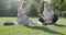 Girls teenage students sitting on green lawn in park with books, digital tablet, talking, laughing