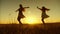 Girls teenagers with long hair whirl in flight under rays of golden sunset. Slow motion.