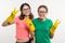 Girls teenagers wearing yellow protective gloves show victory.