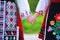 Girls in traditional bulgarian ethnic costumes with folklore embroidery holding hands. The spirit of Bulgaria - culture, history