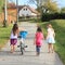 Girls walking and pushing a bike