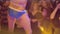 Girls watch at stripper in blue pants boxers dance in front of them in nightclub