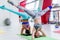 Girls working out together doing wide leg headstand, advanced yoga pose in modern fitness club