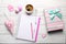 Girly accessories with notebook, cup of coffee and gift box on w