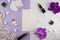 Girly flat lay background. Violet paper background with lipstick, perfume, orchids and jewelry