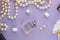Girly flat lay background. Violet paper background with lipstick, perfume, orchids and jewelry