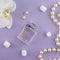 Girly flat lay background. Violet paper background with lipstick, perfume, orchids and jewelry