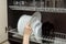 Girlâ€™s graceful hand takes out a clean plate from the cupboard