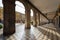 Girona, Independence square, view from arched passage with cafes lit by sunlight